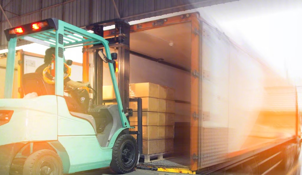 Montacargas cargando pallet a tráiler en operación de cross docking