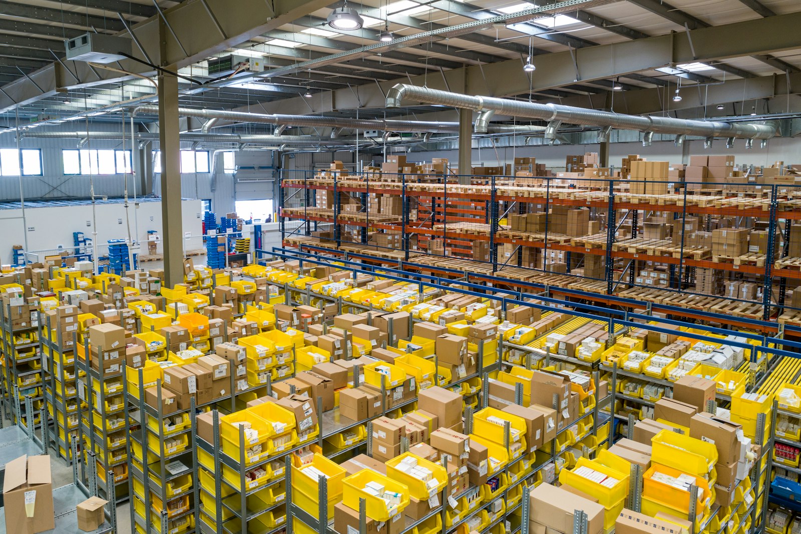 Operadora en CEDIS con tablet frente a racks: inventario liberable listo para el eslabón de distribución