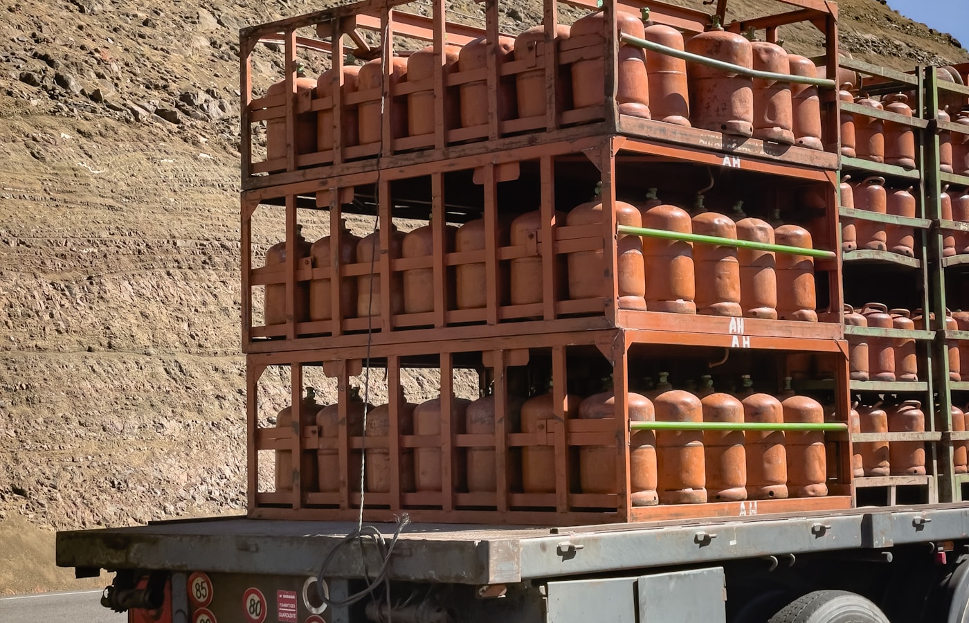 Camión de carga con cilindros de gas en jaulas metálicas listos para transporte terrestre