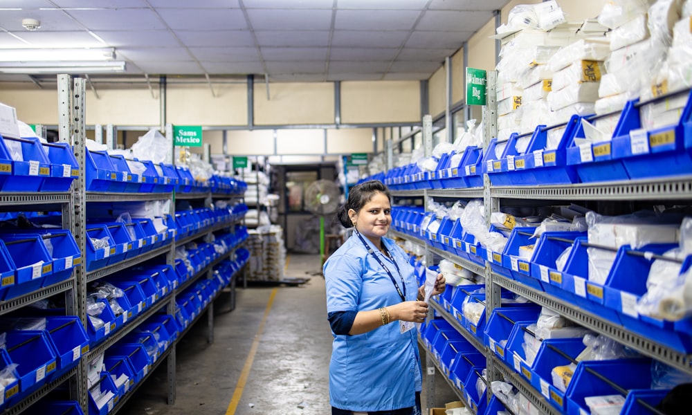 Operadora en pasillo de CEDIS con racks y bins: reabastecimiento físico donde el plan CPFR debe llegar