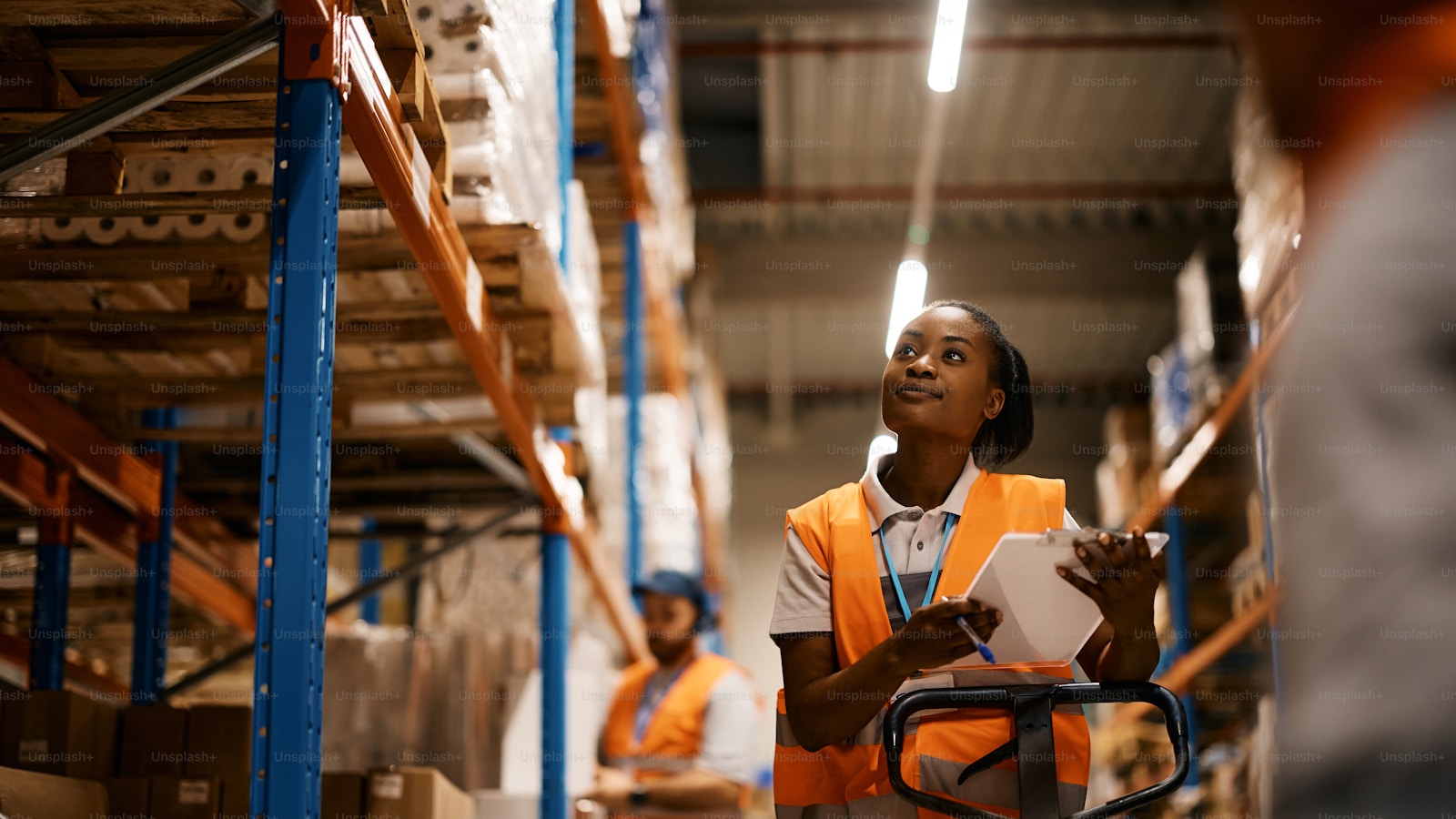 Woman operator in a CEDIS with a tablet coordinating dock loading: shipping as shipment with a trip file