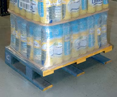Tarima pool azul cargada con packs de botellas y stretch film en piso de almacén